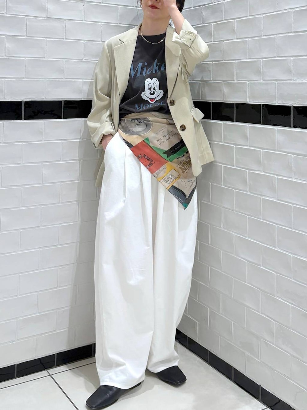 ベージュ系のノーカラージャケット、グレー系のTシャツ/カットソー、レッド系のバンダナ/スカーフを着用したレディースの春コーディネートの2枚目の写真