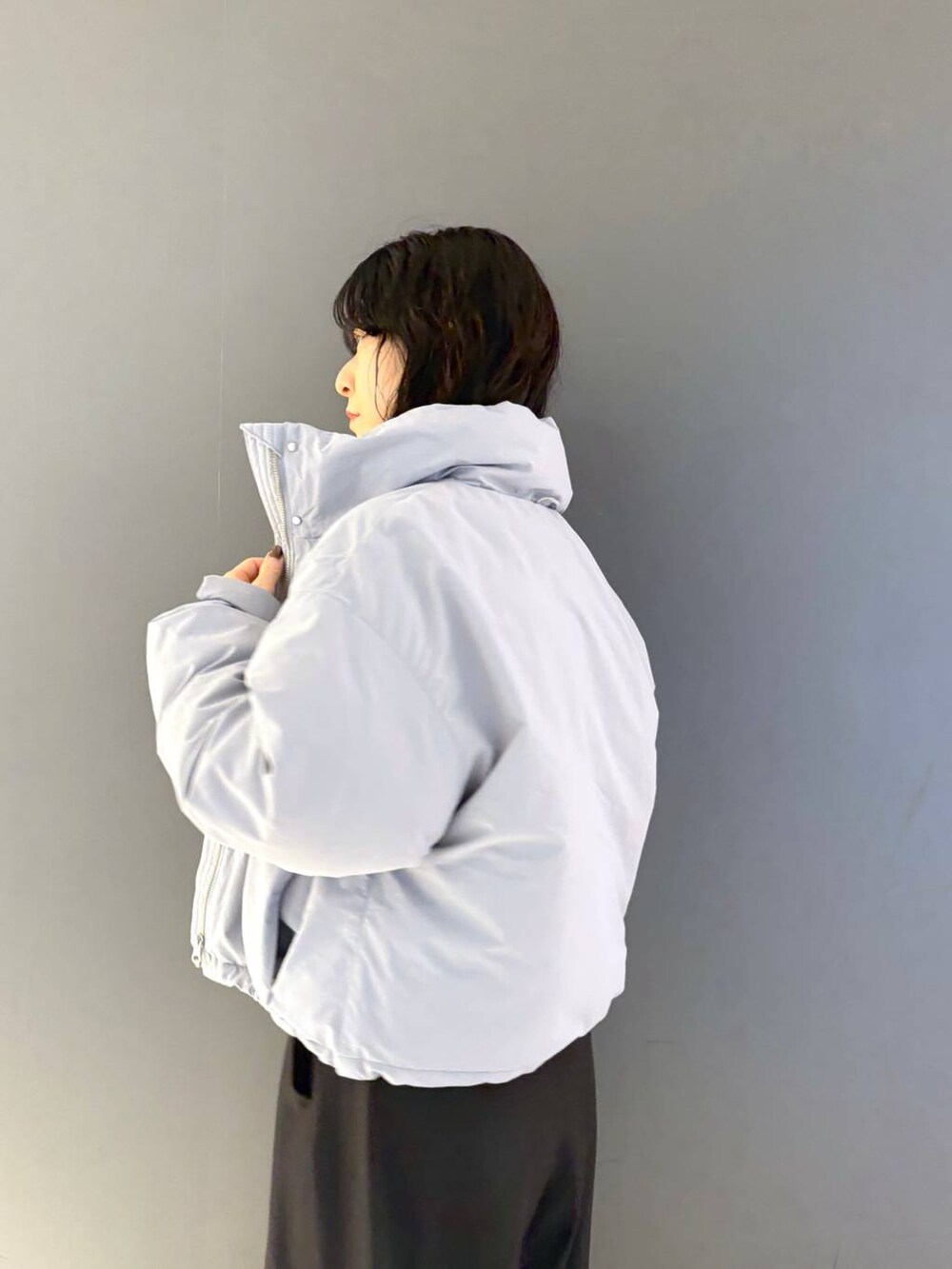 ブラウン系のニット/セーター、ブラック系のスラックス、ブルー系のブルゾンを着用したレディースの冬コーディネートの3枚目の写真