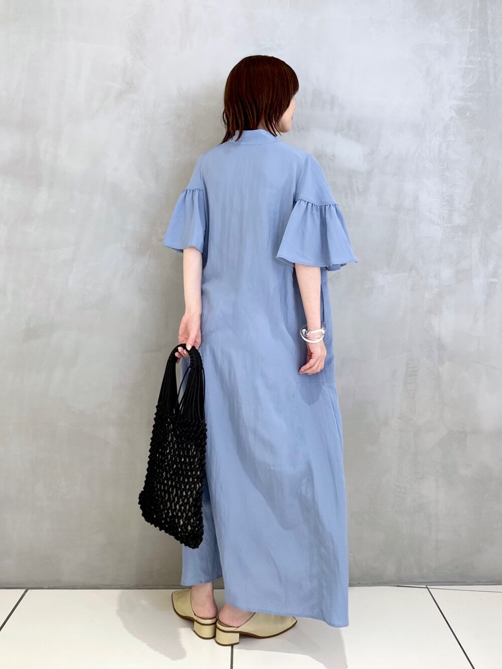 ブルー系のワンピース、ブラック系のハンドバッグを着用したレディースの夏コーディネートの3枚目の写真