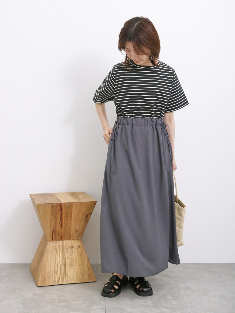 ブラック系のワンピース、ホワイト系のハンドバッグ、ブラック系のドレスシューズを着用したレディースの春コーディネートの3枚目の写真