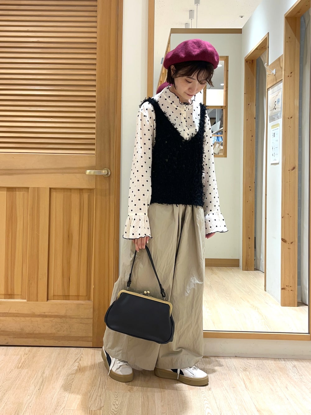 ホワイト系のシャツ/ブラウス、ブラック系のベスト、ベージュ系のその他パンツを着用したレディースの秋コーディネートの2枚目の写真