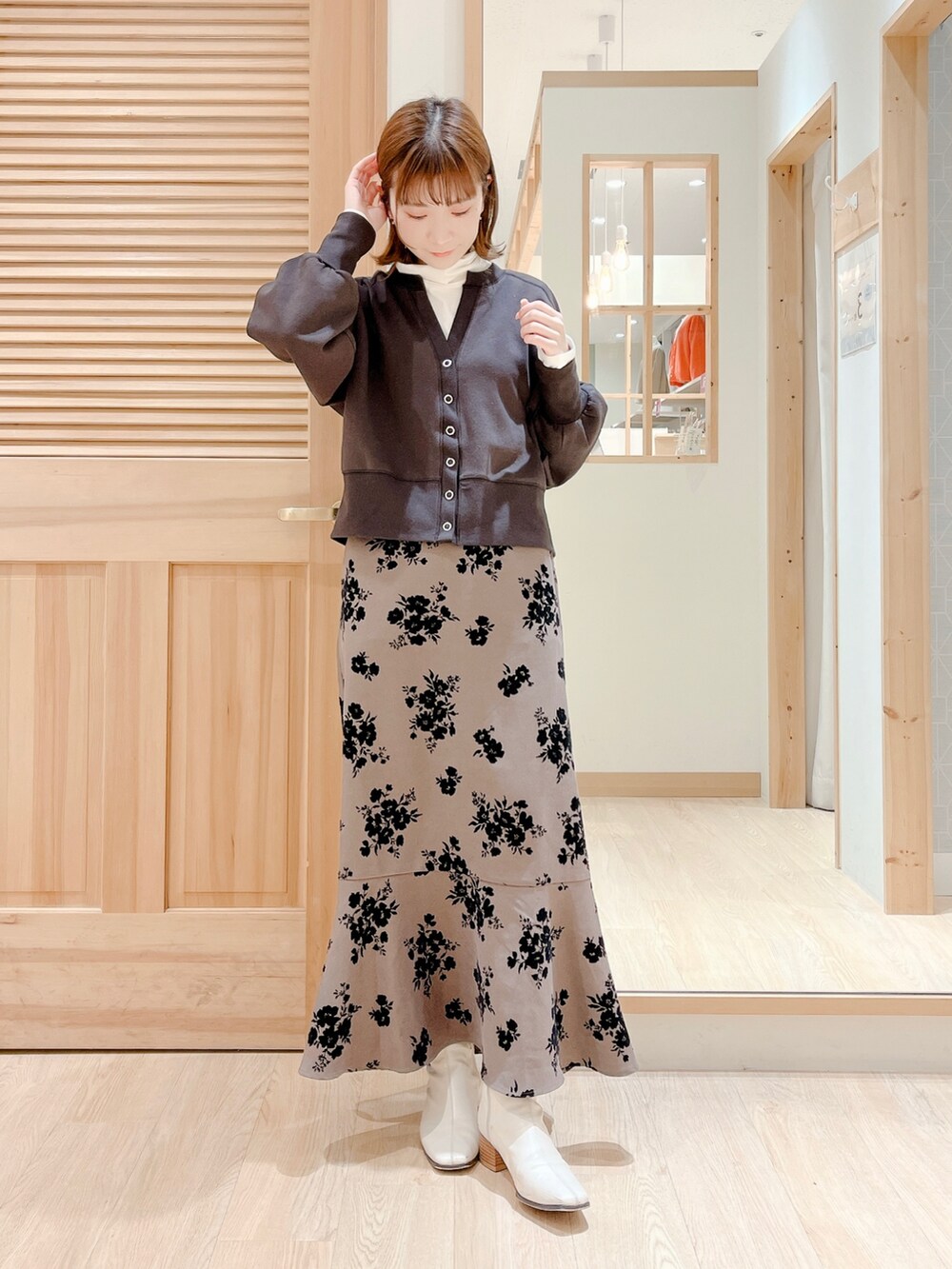 ブラウン系のスカート、グレー系のカーディガン/ボレロ、ホワイト系のTシャツ/カットソーを着用したレディースの冬コーディネートの3枚目の写真