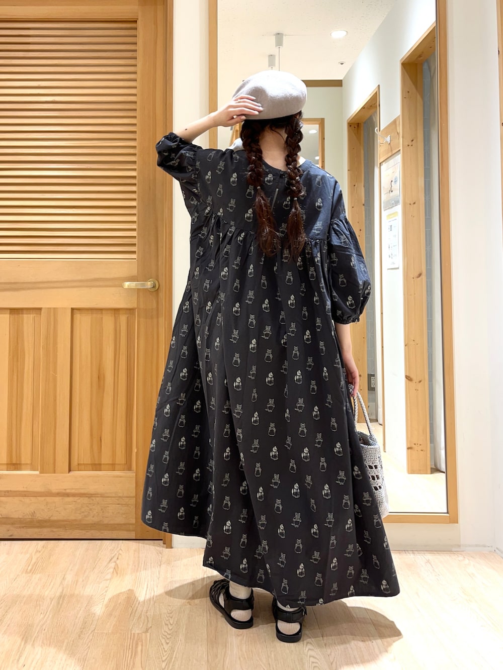 ブラック系のワンピース、シルバー系のハンドバッグ、ブラック系のサンダルを着用したレディースの春コーディネートの3枚目の写真