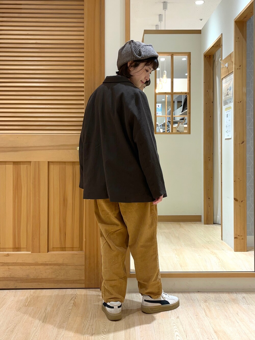 ホワイト系のニット/セーター、ブラック系のジャケット/アウター、イエロー系のパンツを着用したレディースの秋コーディネートの3枚目の写真