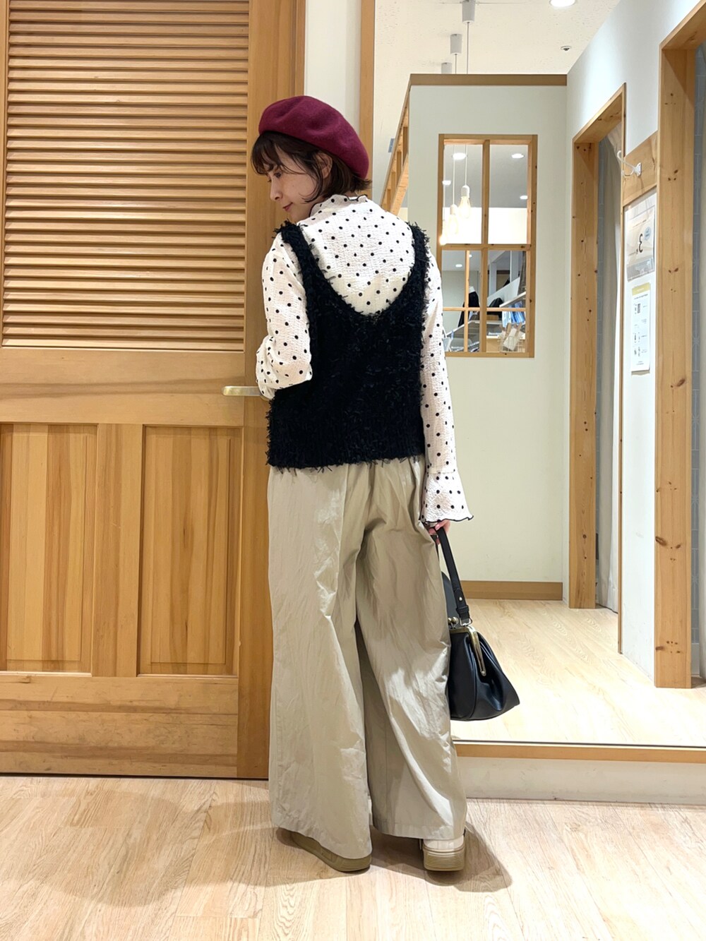 ホワイト系のシャツ/ブラウス、ブラック系のベスト、ベージュ系のその他パンツを着用したレディースの秋コーディネートの3枚目の写真