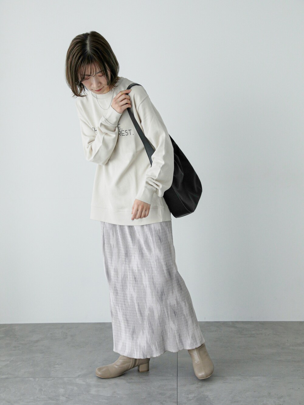 ホワイト系のTシャツ/カットソー、ベージュ系のスカート、ベージュ系のブーツを着用したレディースの冬コーディネートの2枚目の写真