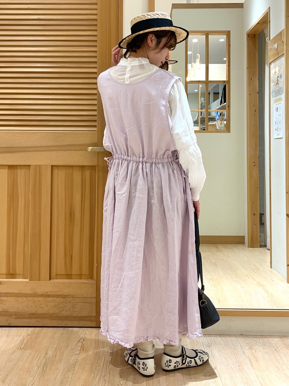 パープル系のワンピース、ホワイト系のシャツ/ブラウス、ブラック系のハンドバッグを着用したレディースの春コーディネートの2枚目の写真