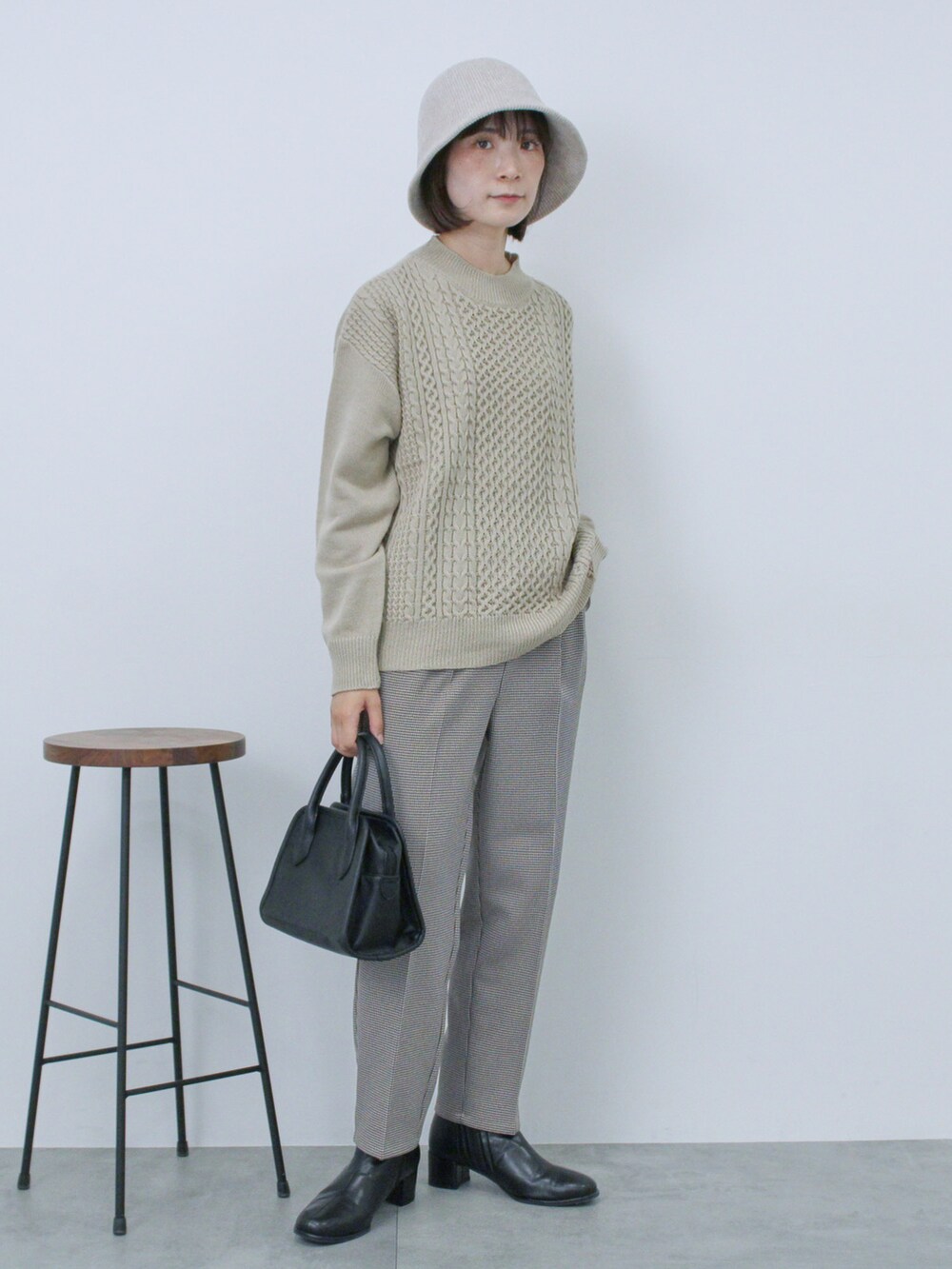 ベージュ系のニット/セーター、ブラック系のハンドバッグ、ブラック系のドレスシューズを着用したレディースの秋コーディネートの3枚目の写真