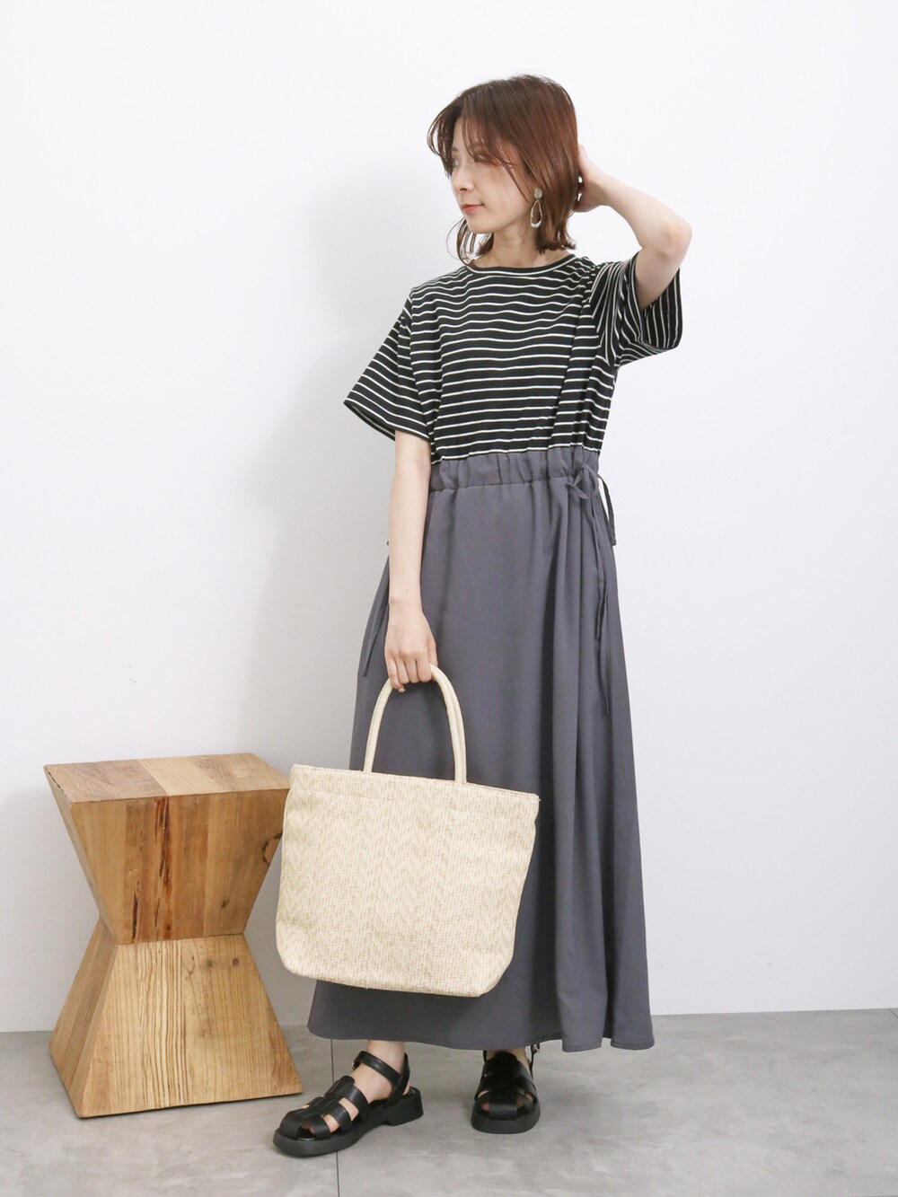 ブラック系のワンピース、ホワイト系のハンドバッグ、ブラック系のドレスシューズを着用したレディースの春コーディネートの2枚目の写真