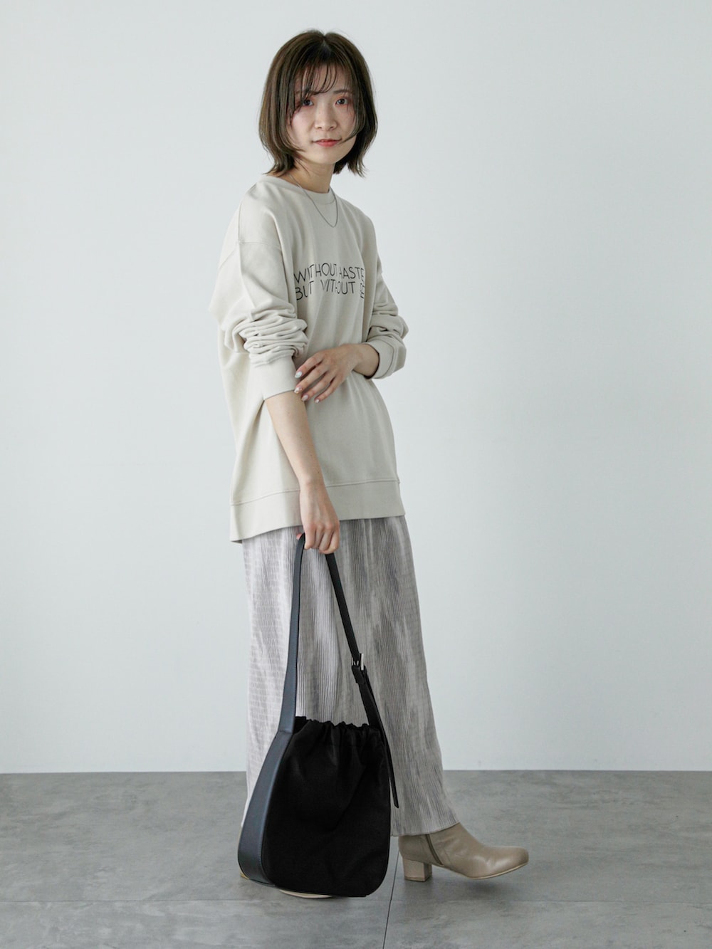 ホワイト系のTシャツ/カットソー、ベージュ系のスカート、ベージュ系のブーツを着用したレディースの冬コーディネートの3枚目の写真