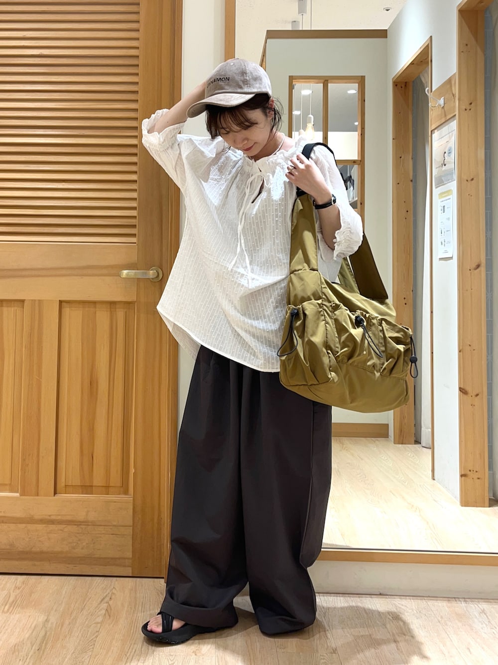 ホワイト系のシャツ/ブラウス、グレー系のその他パンツ、ベージュ系のハンドバッグを着用したレディースの夏コーディネートの2枚目の写真