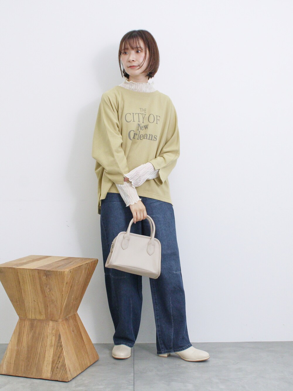 ベージュ系のハンドバッグ、イエロー系のTシャツ/カットソー、ホワイト系のTシャツ/カットソーを着用したレディースの秋コーディネートの2枚目の写真
