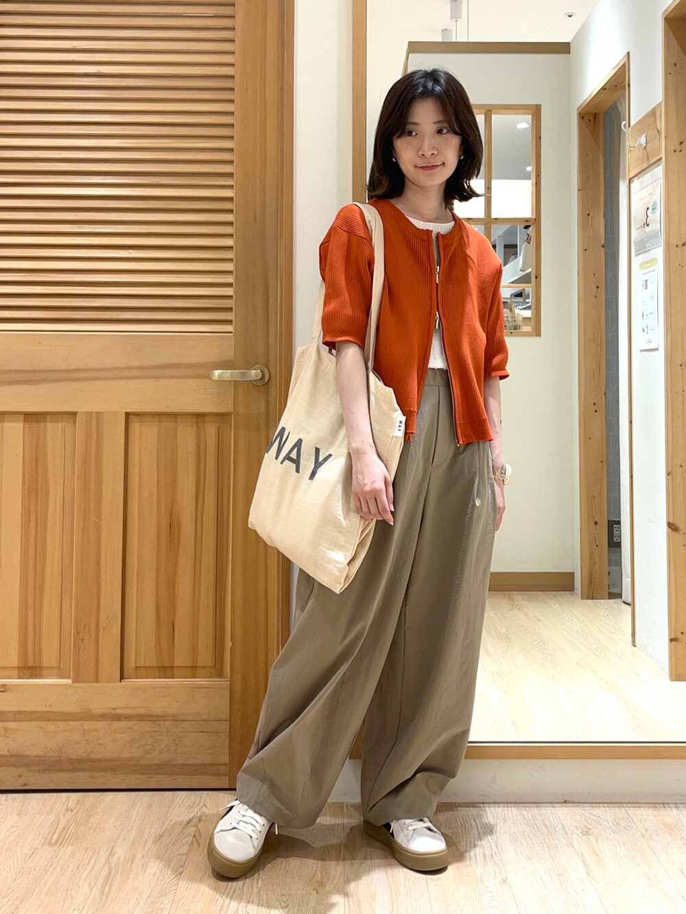 オレンジ系のカーディガン/ボレロ、ホワイト系のTシャツ/カットソー、ブラウン系のその他パンツを着用したレディースの夏コーディネートの4枚目の写真