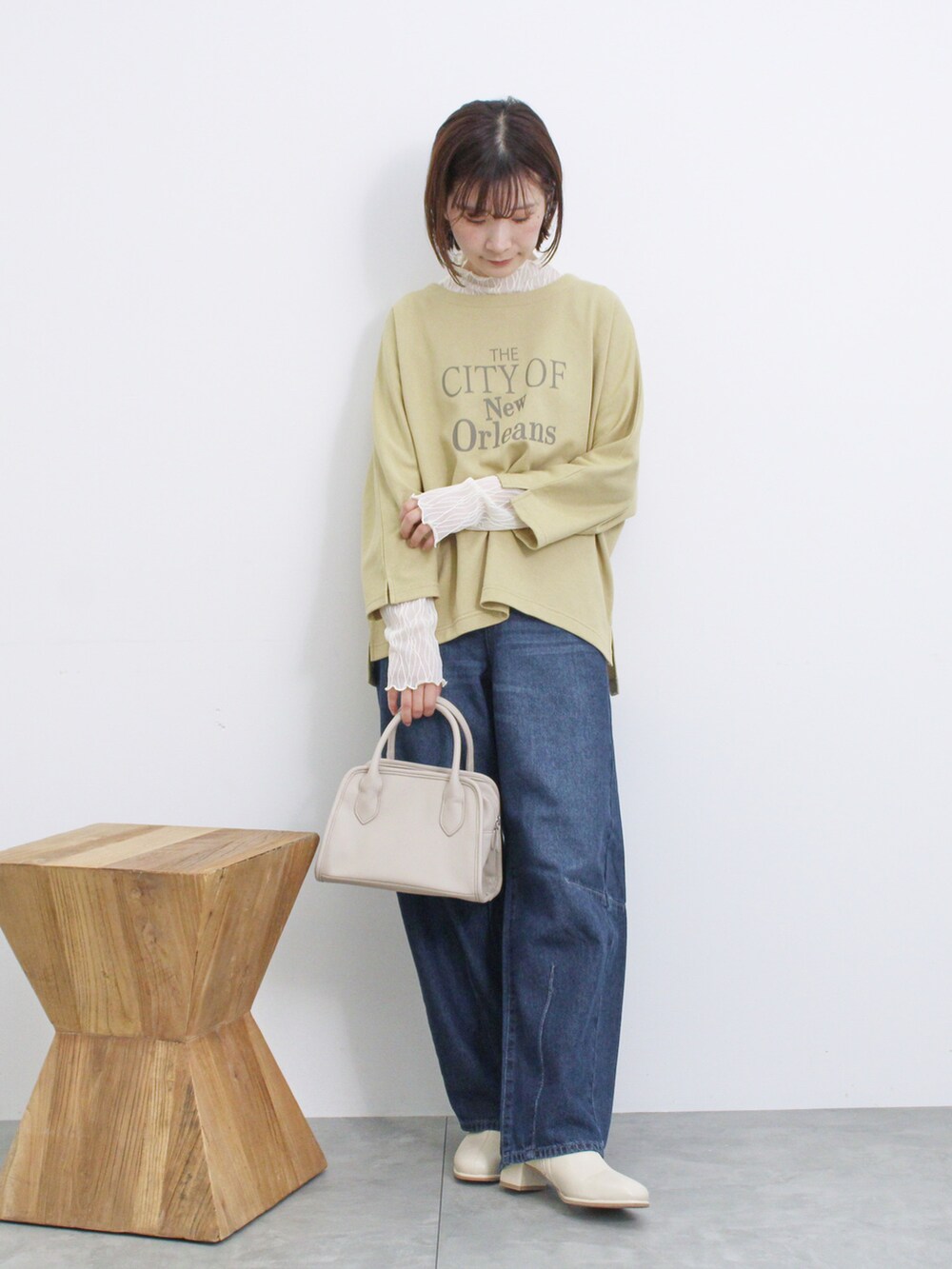 ベージュ系のハンドバッグ、イエロー系のTシャツ/カットソー、ホワイト系のTシャツ/カットソーを着用したレディースの秋コーディネートの3枚目の写真