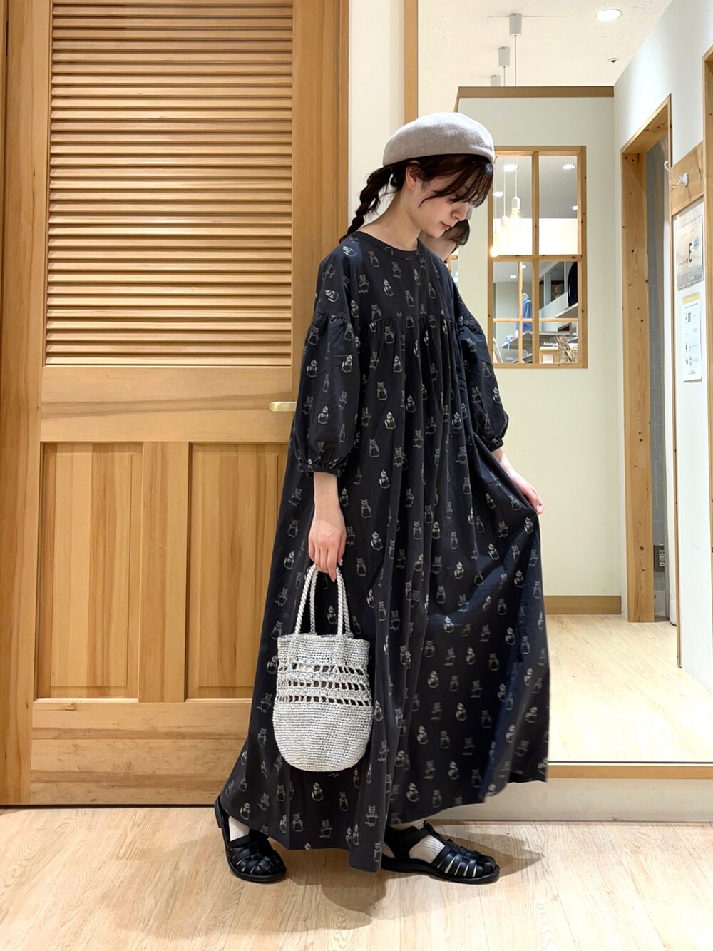 ブラック系のワンピース、シルバー系のハンドバッグ、ブラック系のサンダルを着用したレディースの春コーディネートの2枚目の写真