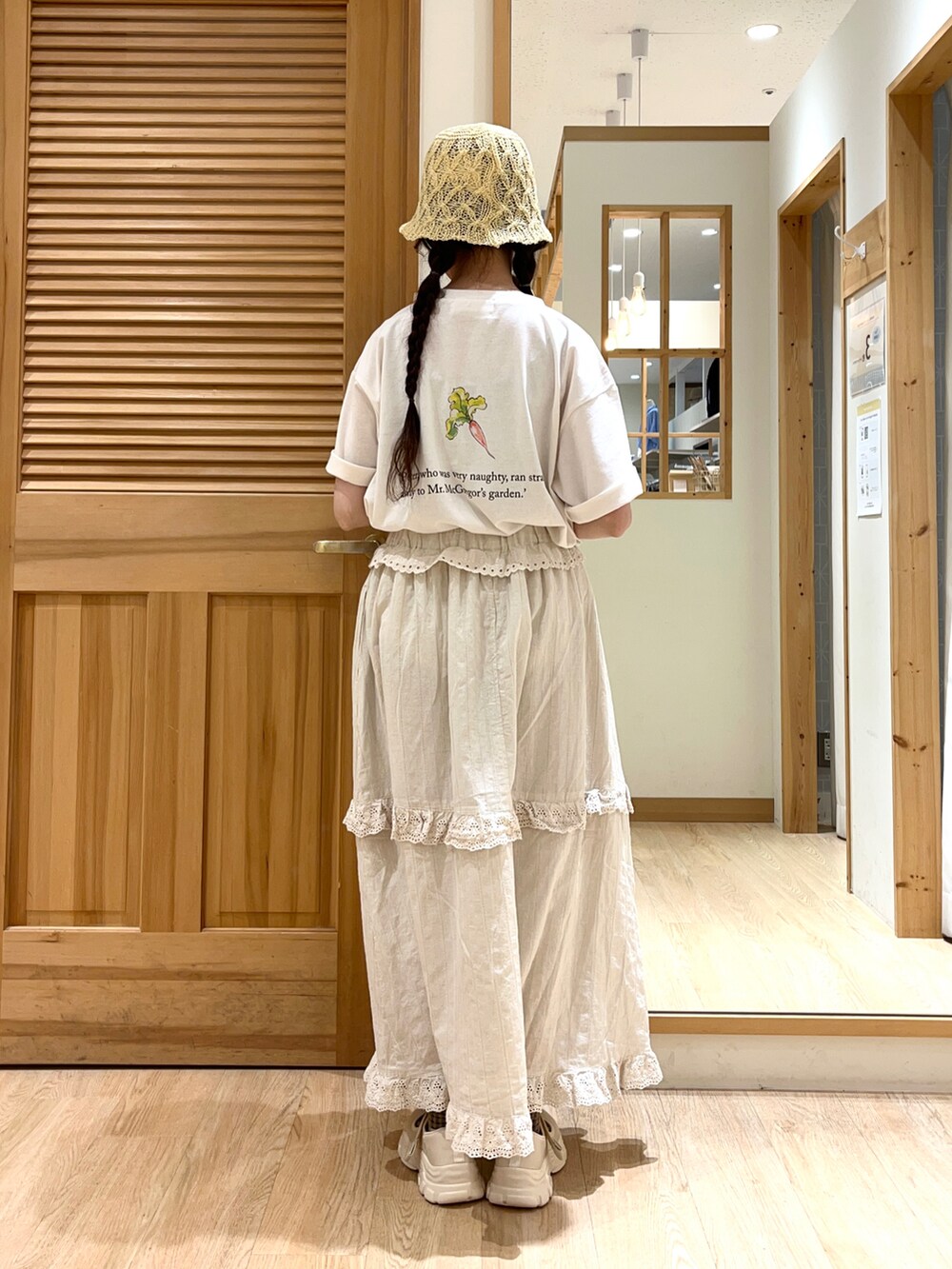 ホワイト系のTシャツ/カットソー、ベージュ系のスカート、ベージュ系のスニーカーを着用したレディースの春コーディネートの3枚目の写真