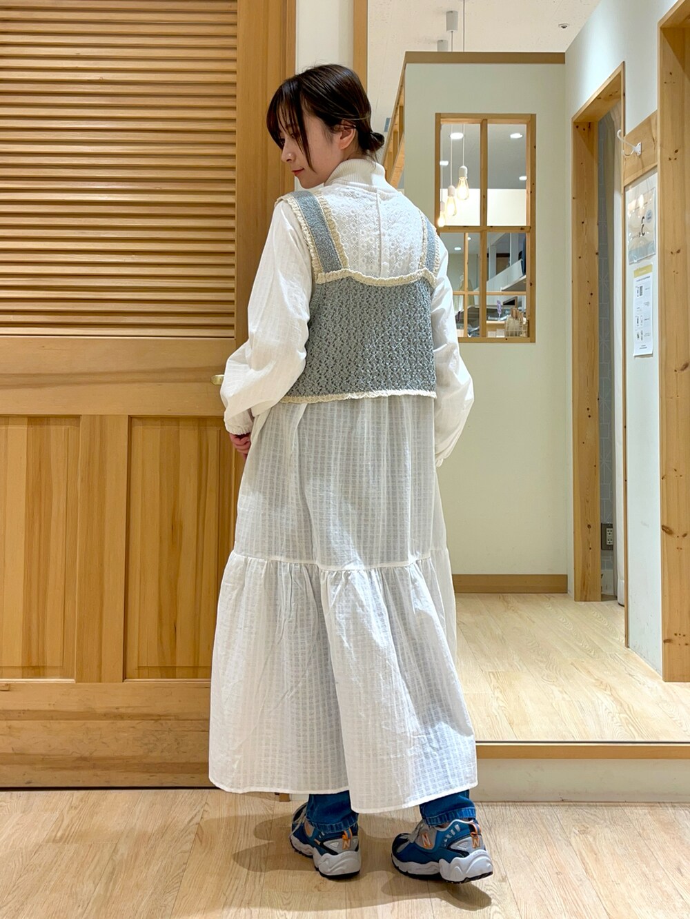 ホワイト系のワンピース、ブルー系のベスト、ホワイト系のニット/セーターを着用したレディースの冬コーディネートの2枚目の写真