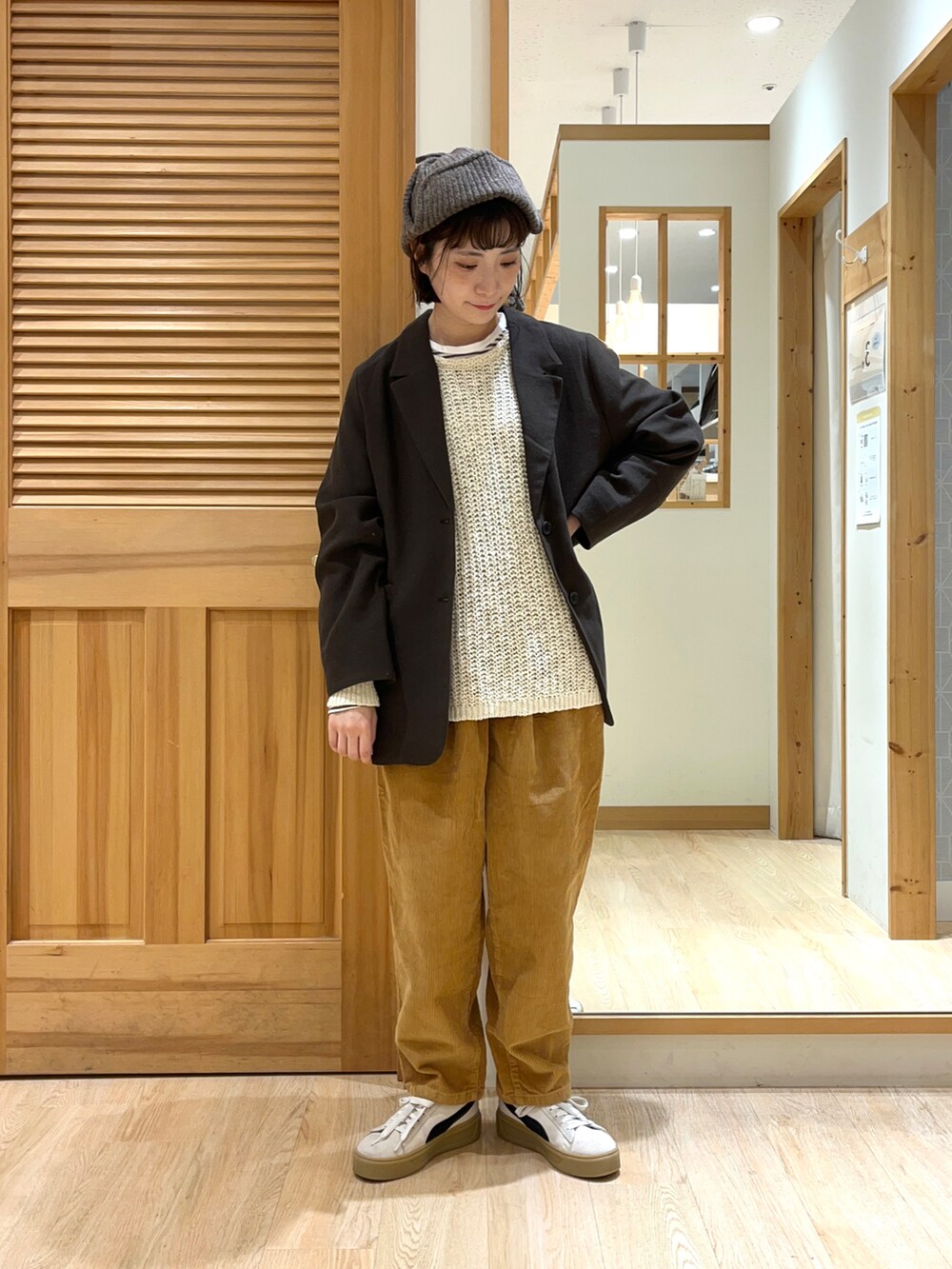 ホワイト系のニット/セーター、ブラック系のジャケット/アウター、イエロー系のパンツを着用したレディースの秋コーディネートの2枚目の写真