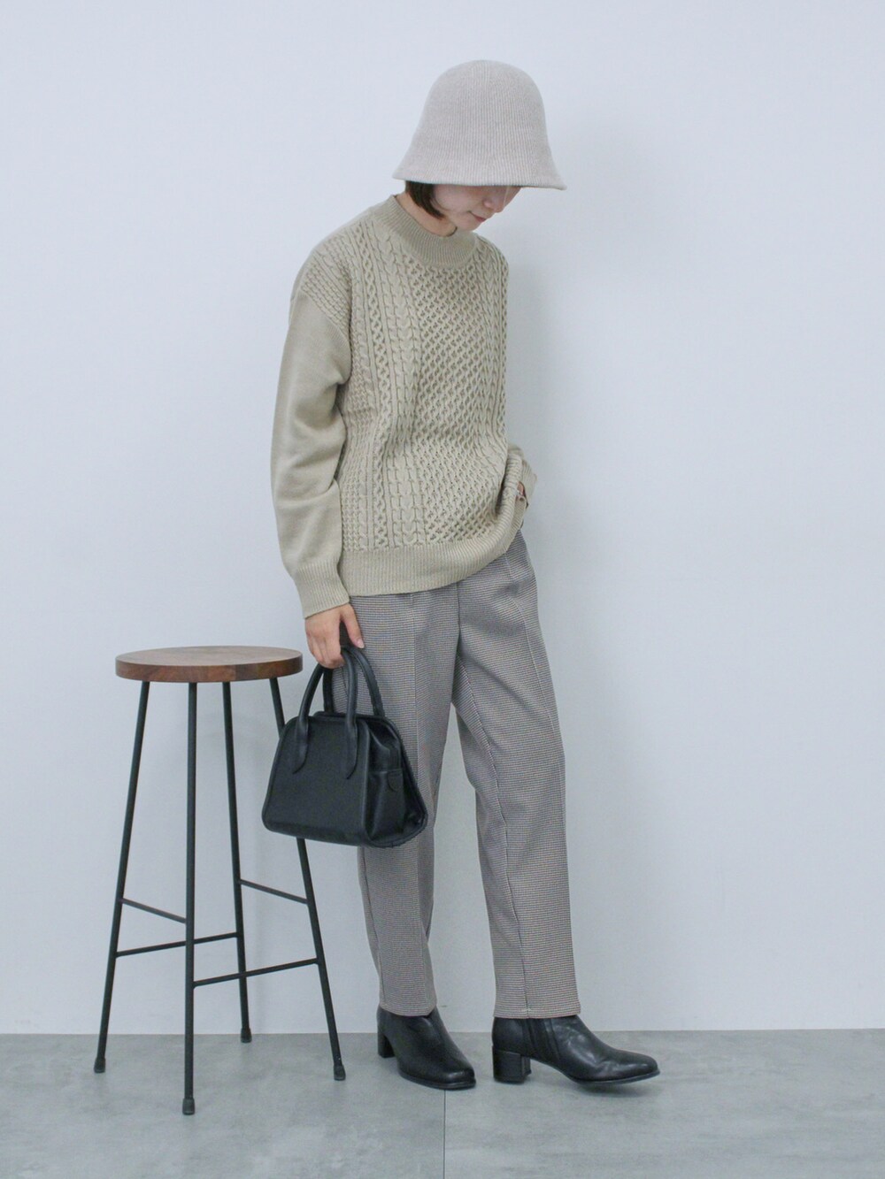 ベージュ系のニット/セーター、ブラック系のハンドバッグ、ブラック系のドレスシューズを着用したレディースの秋コーディネートの4枚目の写真