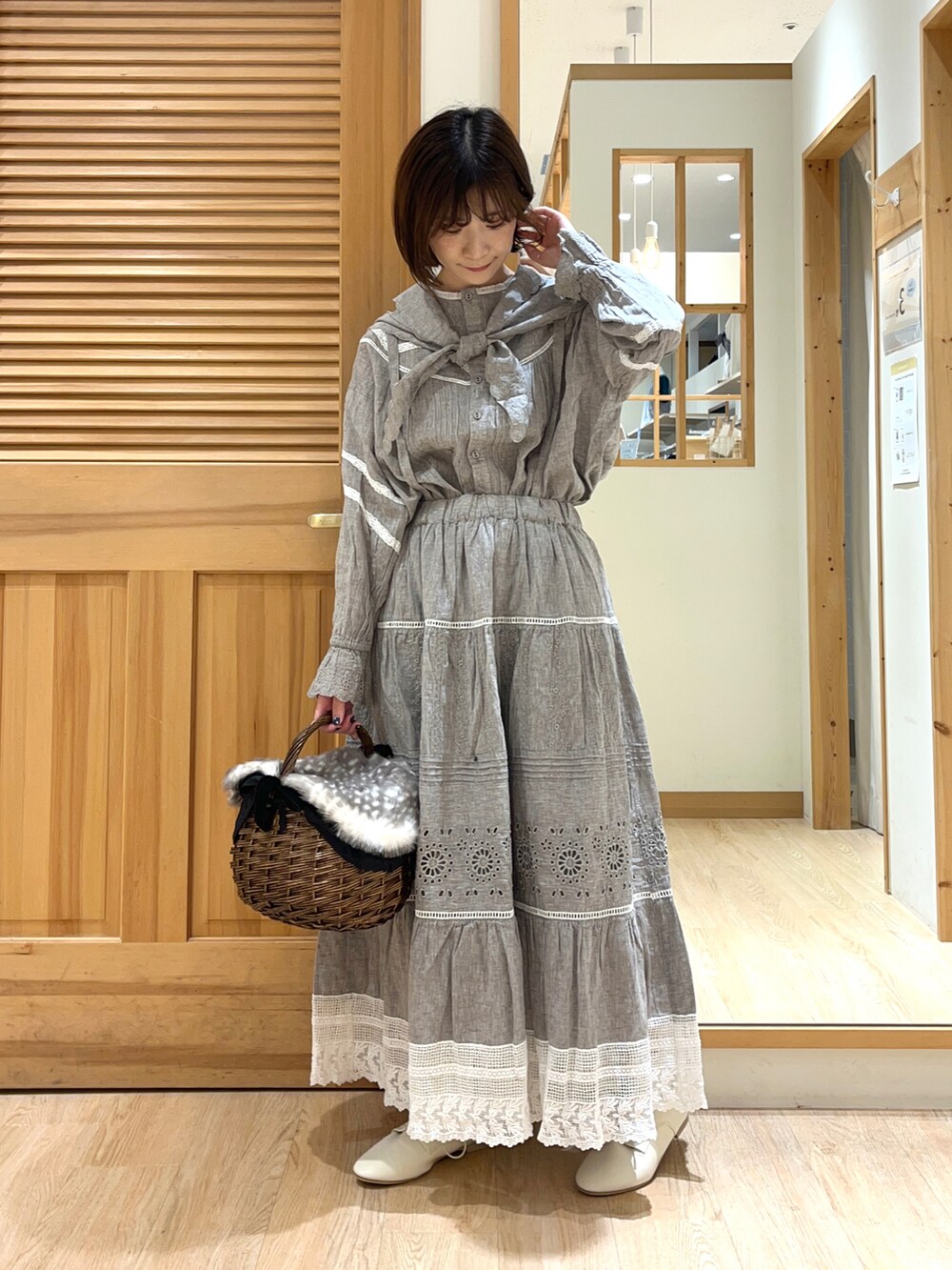 ブラック系のバッグ、グレー系のシャツ/ブラウス、グレー系のスカートを着用したレディースの夏コーディネートの2枚目の写真