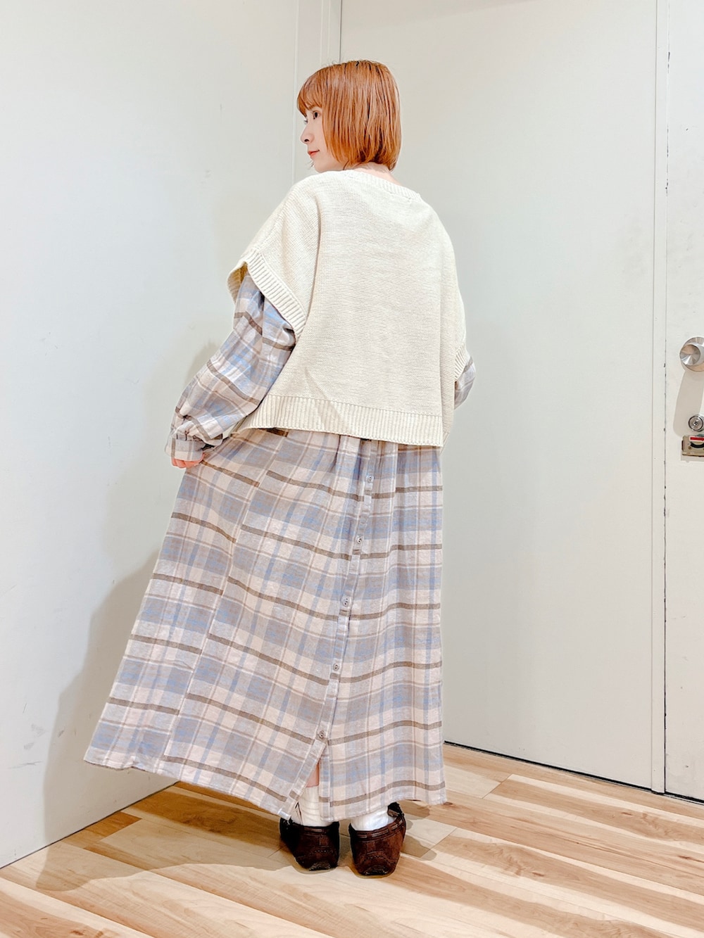 ホワイト系のトートバッグ、ホワイト系のカーディガン/ボレロ、ブルー系のワンピースを着用したレディースの冬コーディネートの2枚目の写真