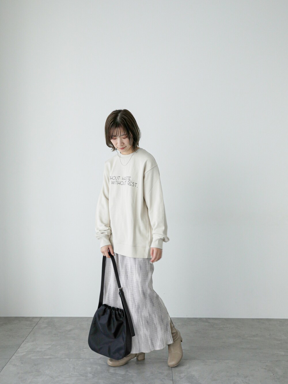 ホワイト系のTシャツ/カットソー、ベージュ系のスカート、ベージュ系のブーツを着用したレディースの冬コーディネートの4枚目の写真