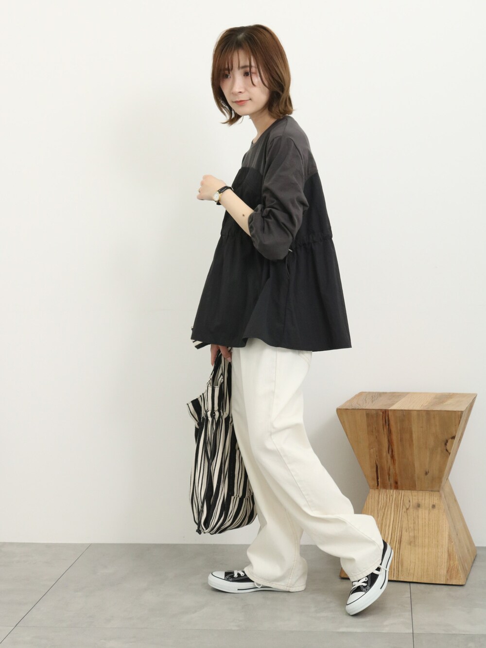 ブラック系のTシャツ/カットソー、ブラック系のバッグ、ホワイト系のその他パンツを着用したレディースの春コーディネートの3枚目の写真