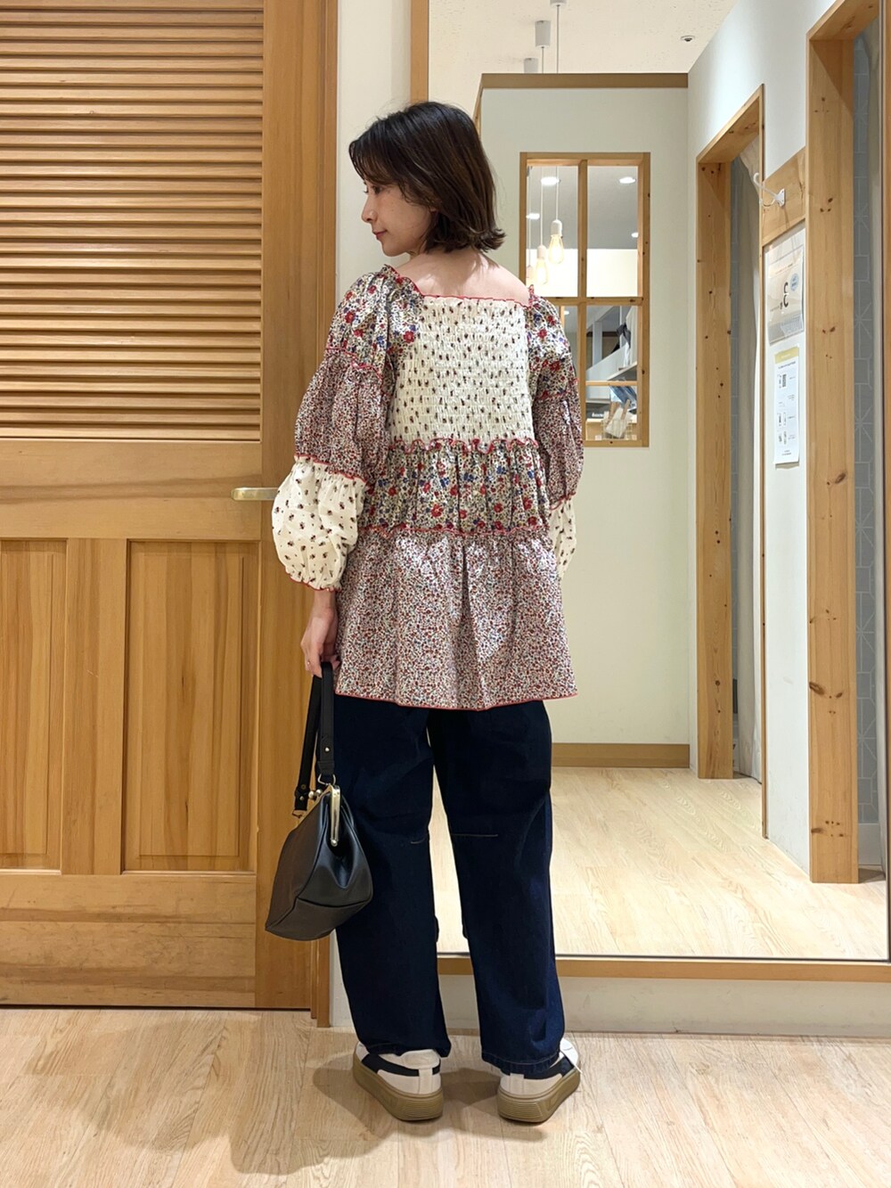 ブラック系のハンドバッグ、ブルー系のその他パンツ、ホワイト系のシャツ/ブラウスを着用したレディースの秋コーディネートの3枚目の写真