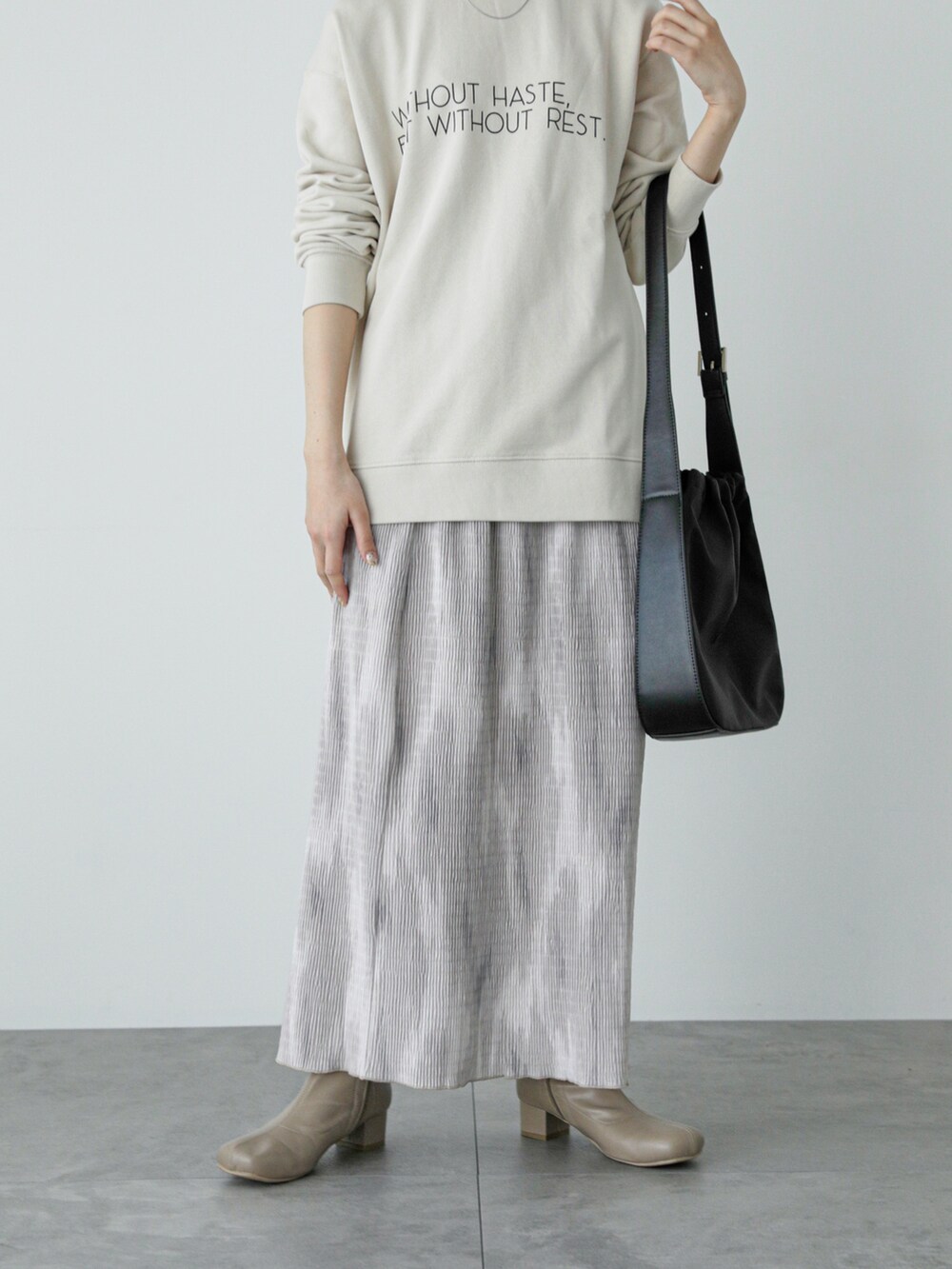 ホワイト系のTシャツ/カットソー、ベージュ系のスカート、ベージュ系のブーツを着用したレディースの冬コーディネートの5枚目の写真