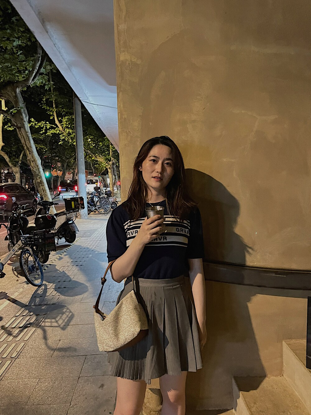 ホワイト系のトートバッグ、グレー系のスカート、ブルー系のTシャツ/カットソーを着用したレディースの夏コーディネートの2枚目の写真