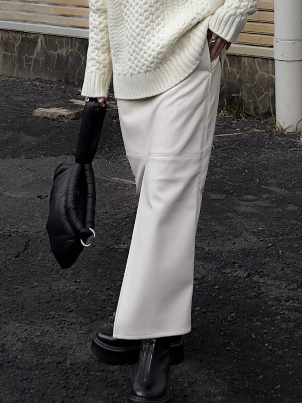 ホワイト系のニット/セーター、ホワイト系のスカート、ブラック系のブーツを着用したレディースの冬コーディネートの3枚目の写真