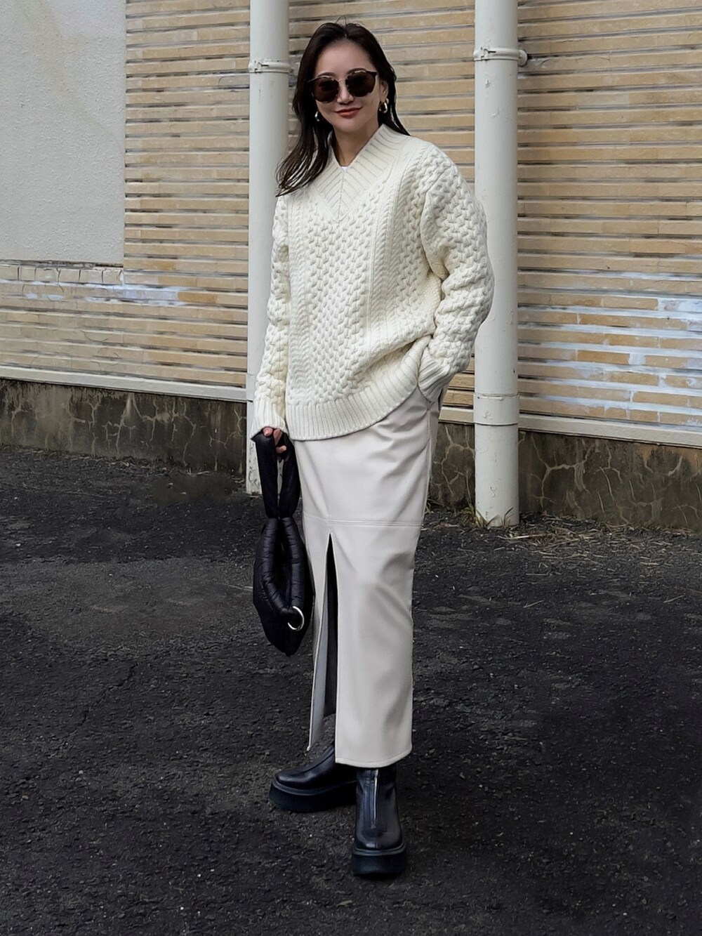 ホワイト系のニット/セーター、ホワイト系のスカート、ブラック系のブーツを着用したレディースの冬コーディネートの4枚目の写真