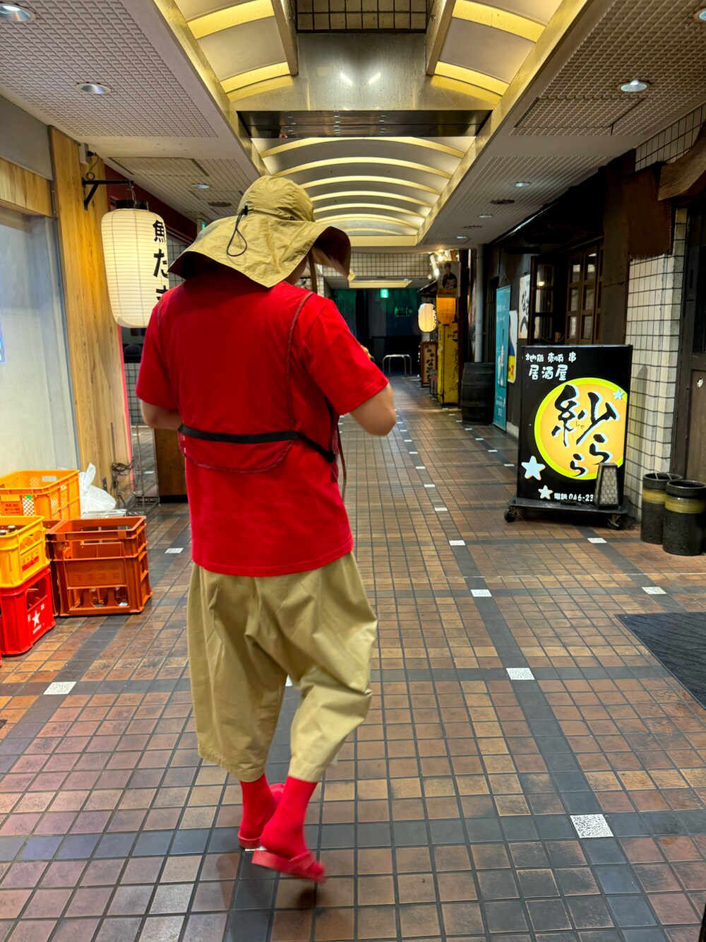 レッド系のベスト、レッド系のTシャツ/カットソー、ベージュ系のその他パンツを着用したメンズの夏コーディネートの2枚目の写真