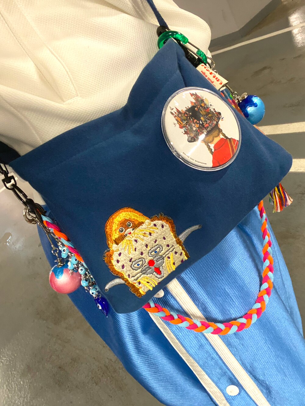 ホワイト系のジャージ、ブルー系のパンツ、グレー系のスニーカーを着用したメンズの春コーディネートの4枚目の写真