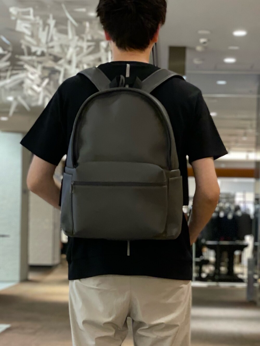 グレー系のバックパック/リュック、ベージュ系のその他パンツ、ブラック系のスニーカーを着用したメンズの夏コーディネートの3枚目の写真