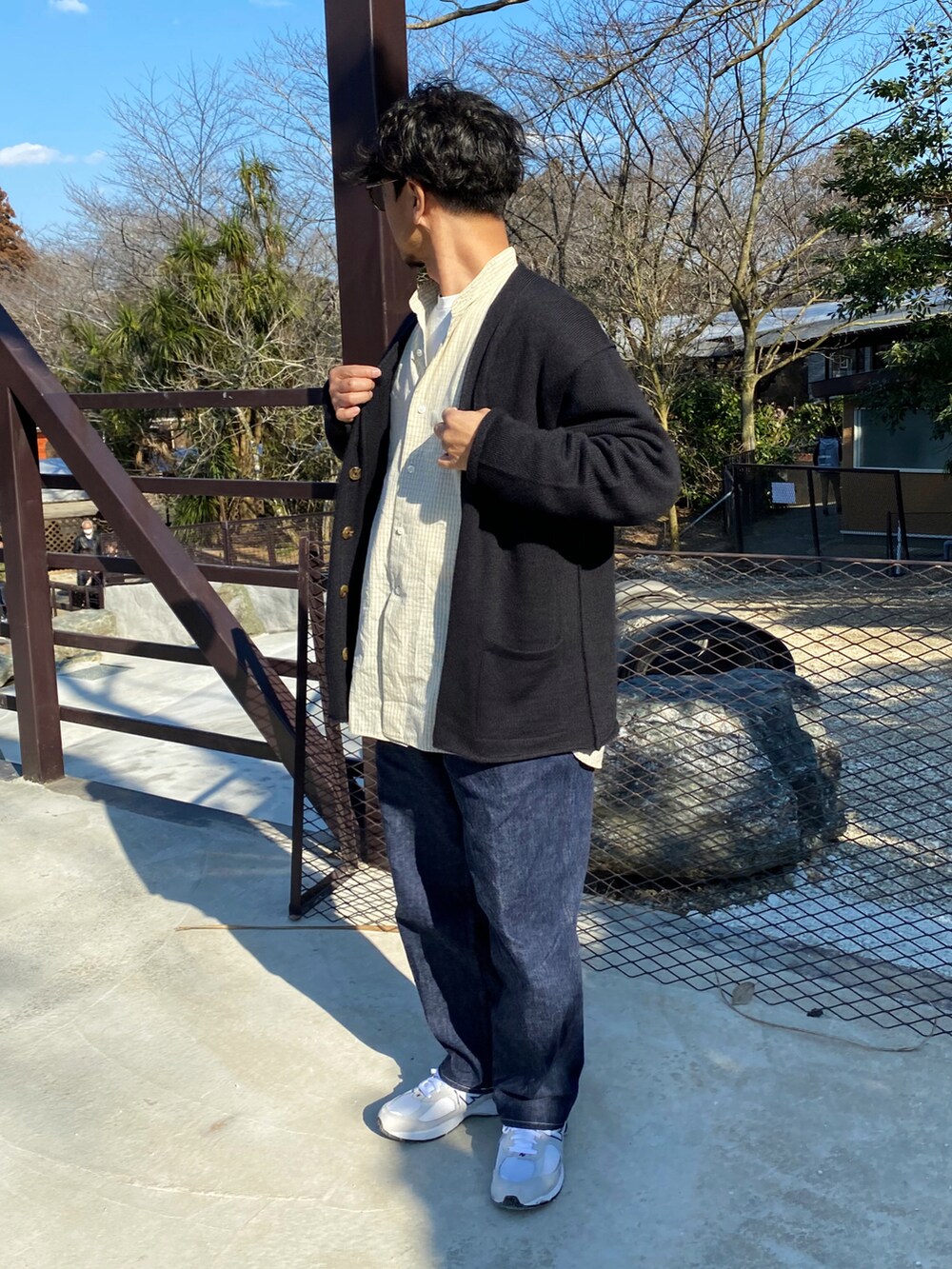 ブラック系のカーディガン/ボレロ、ベージュ系のシャツ/ブラウス、ブルー系のデニムパンツを着用したメンズの春コーディネートの2枚目の写真