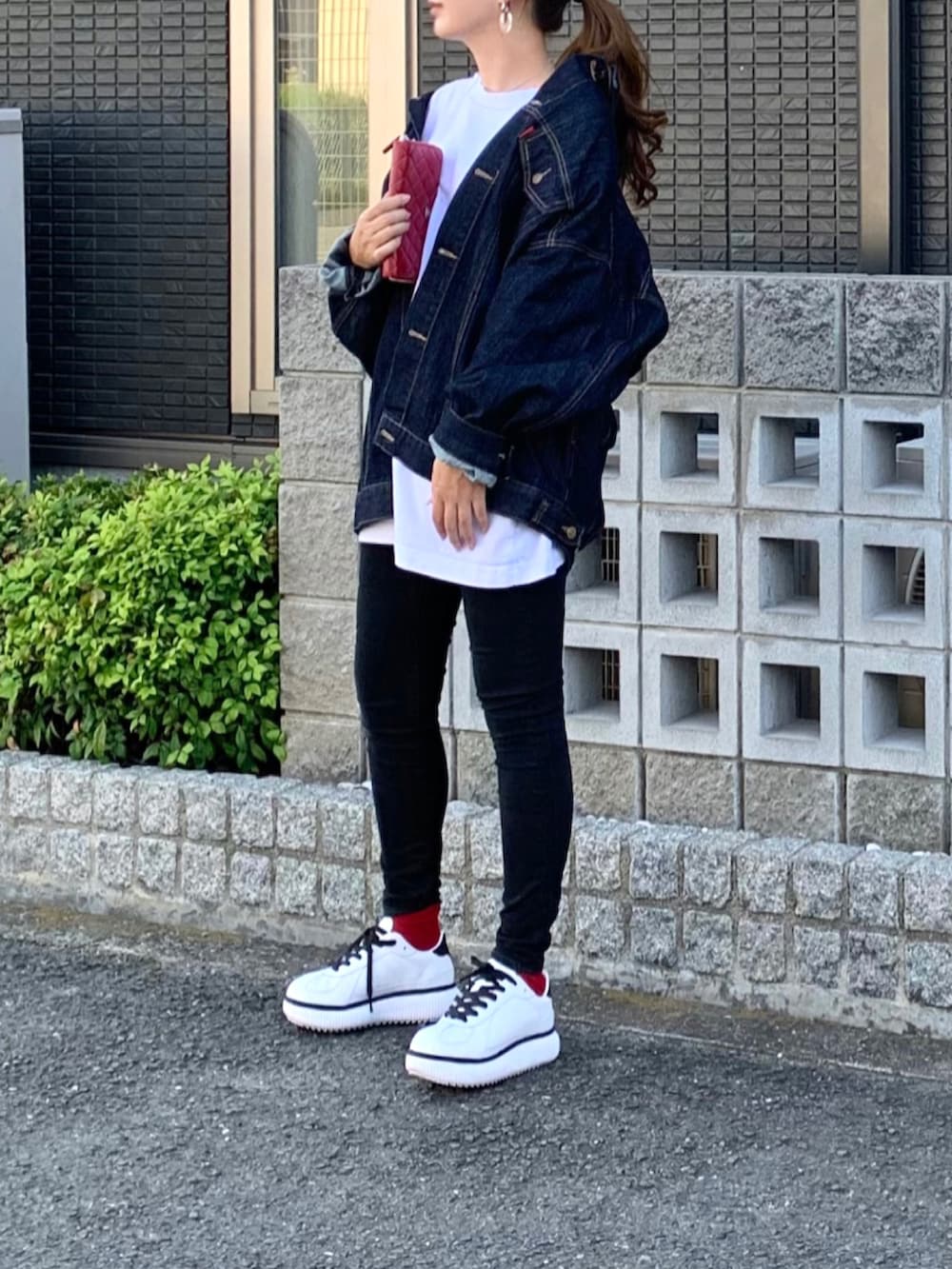 ブルー系のデニムジャケット、ブラック系のデニムパンツ、ホワイト系のスニーカーを着用したレディースの秋コーディネートの2枚目の写真