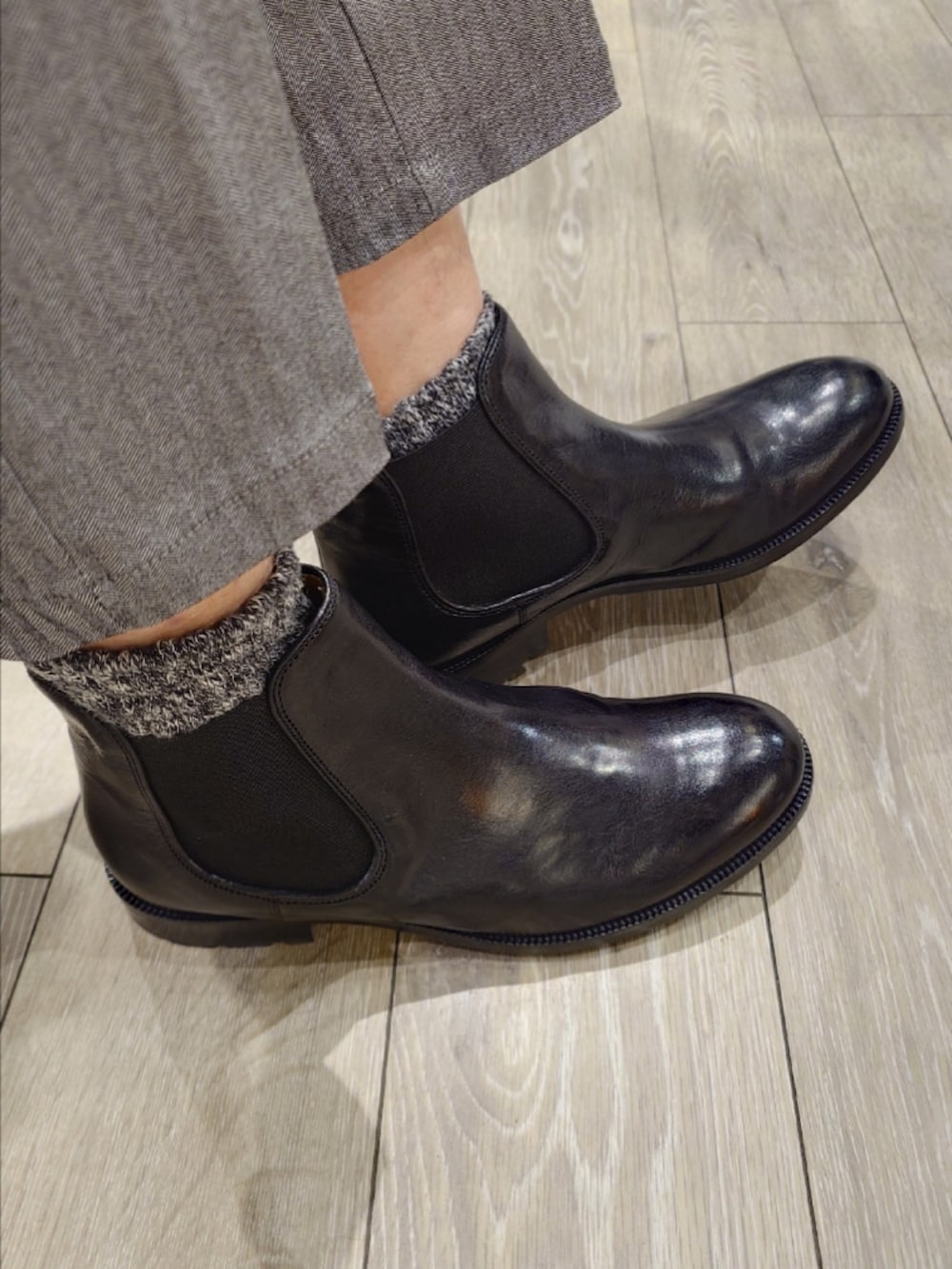 ホワイト系のニット/セーター、グレー系のスラックス、ブラック系のブーツを着用したメンズの冬コーディネートの7枚目の写真