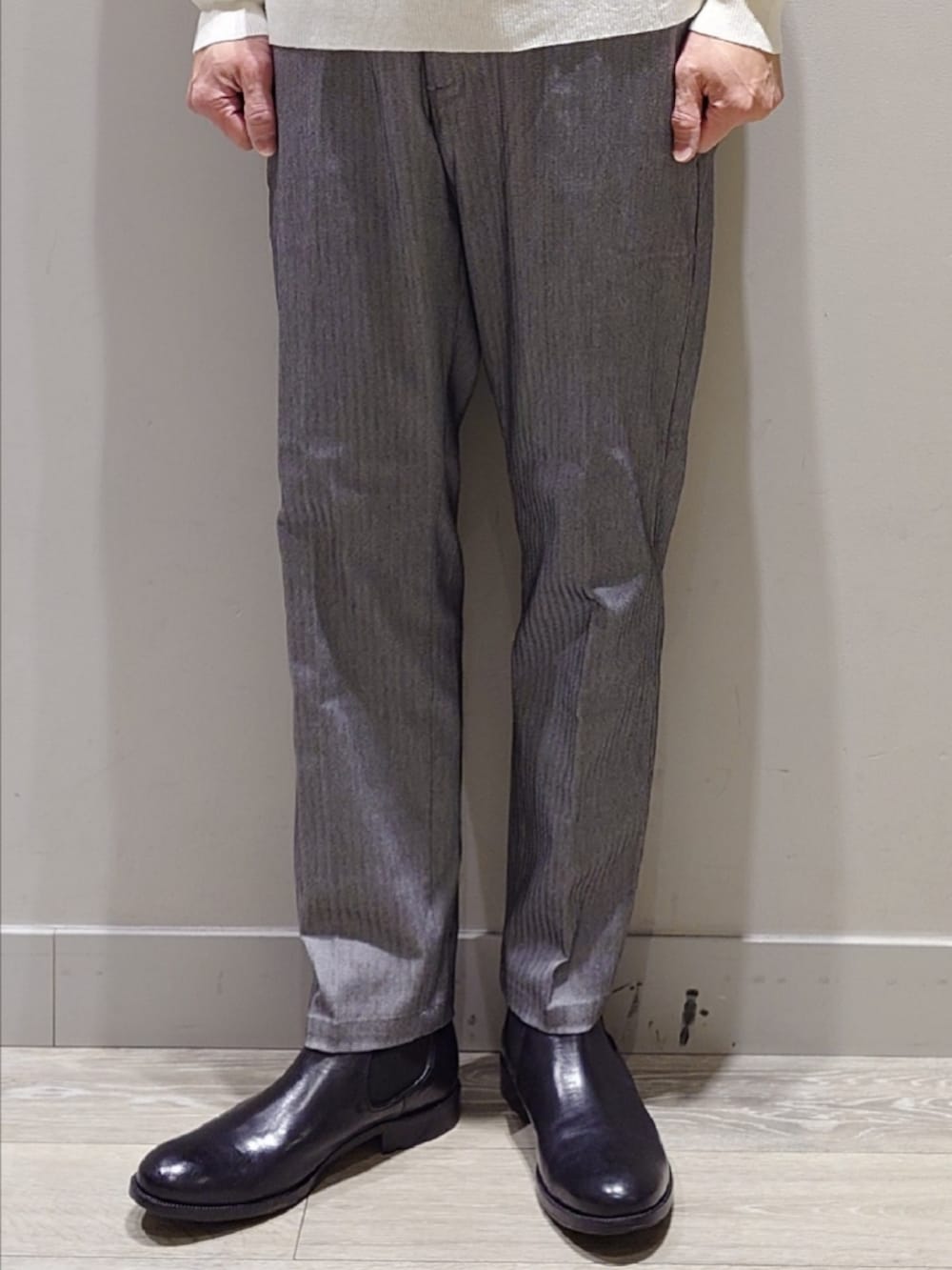 ホワイト系のニット/セーター、グレー系のスラックス、ブラック系のブーツを着用したメンズの冬コーディネートの6枚目の写真