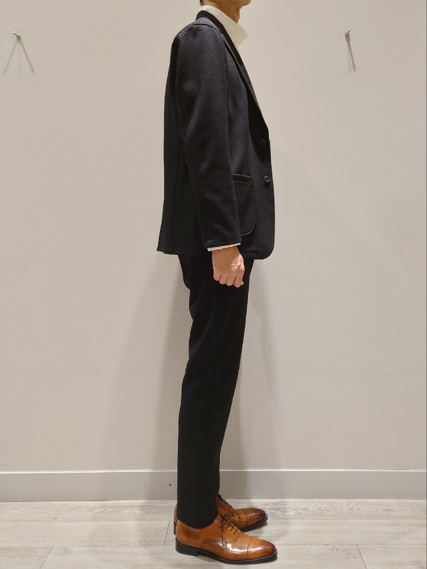 ブラック系のテーラードジャケット、ブラック系のその他パンツ、ホワイト系のTシャツ/カットソーを着用したメンズの秋コーディネートの3枚目の写真