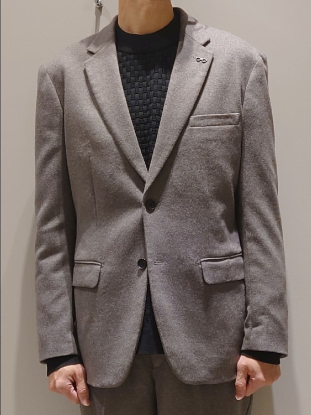 グレー系のテーラードジャケット、グレー系のスラックス、ブラック系のニット/セーターを着用したメンズの冬コーディネートの5枚目の写真