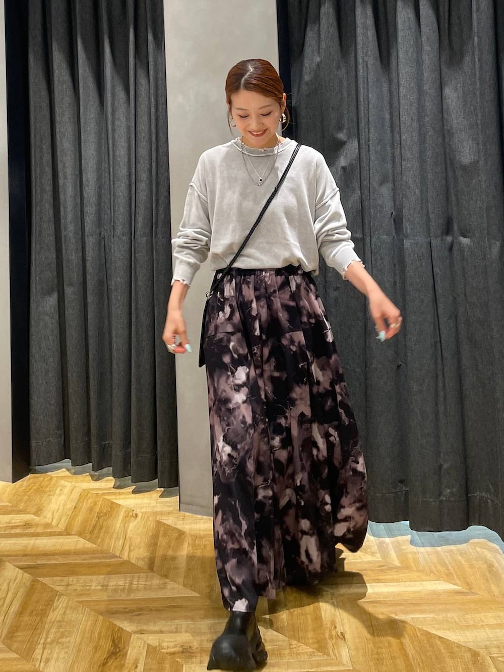 ブラック系のブーツ、グレー系のスカート、グレー系のニット/セーターを着用したレディースの秋コーディネートの3枚目の写真