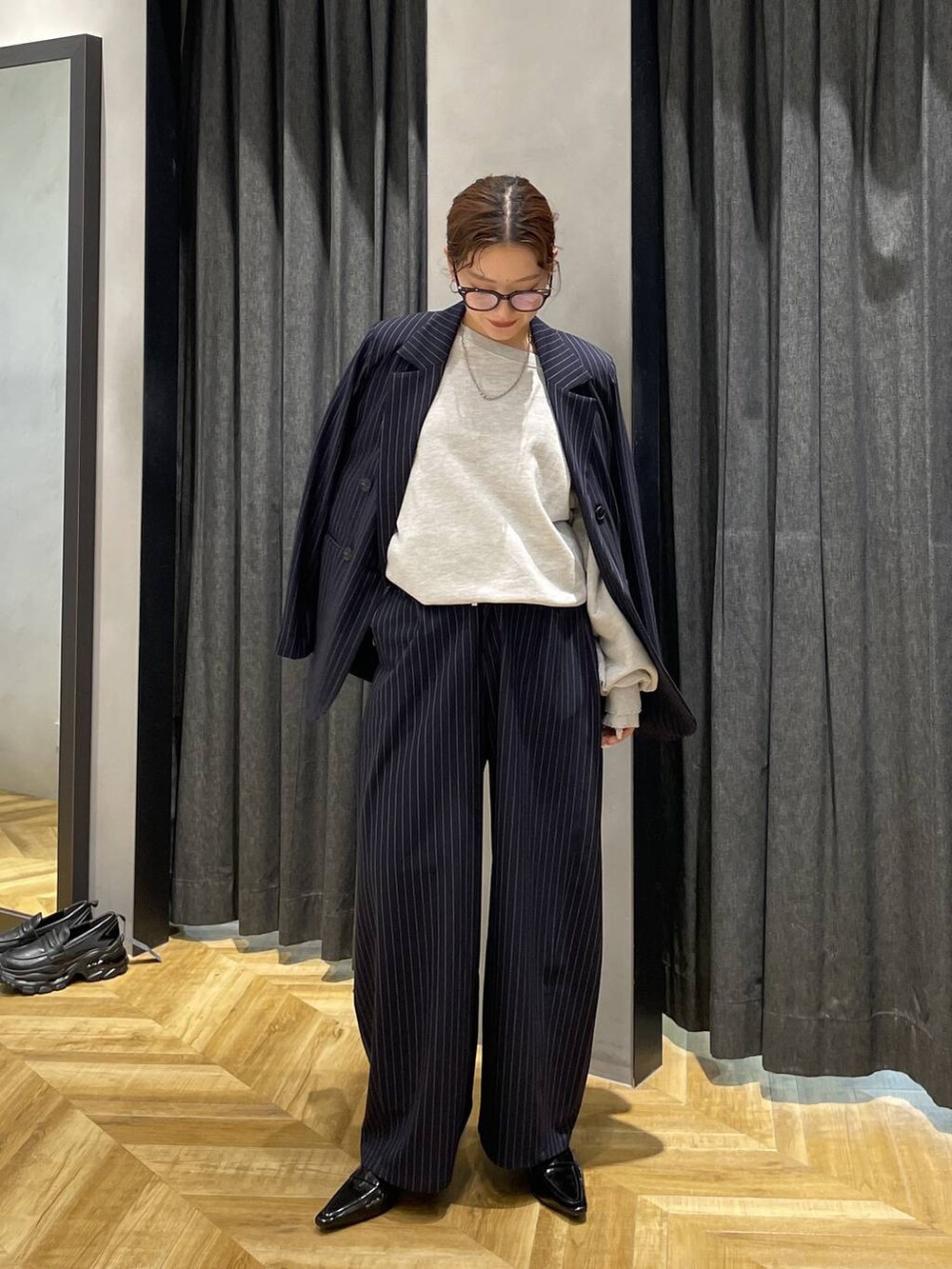 ブラック系のローファー、グレー系のスウェット、ブルー系のスラックスを着用したレディースの冬コーディネートの2枚目の写真