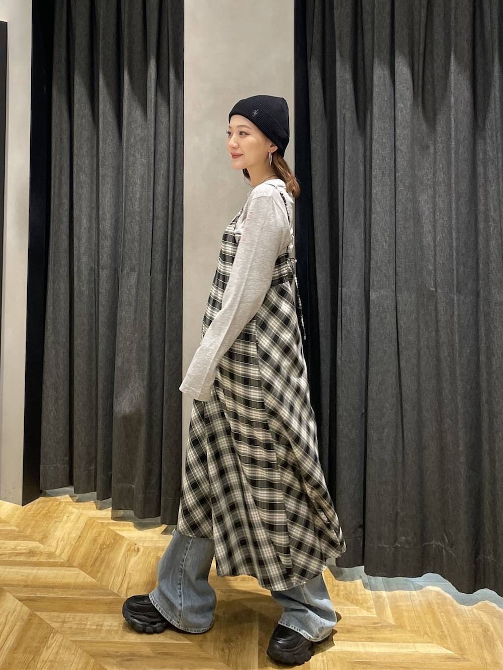 ブラック系のローファー、ブルー系のデニムパンツ、ブラック系のワンピースを着用したレディースの春コーディネートの5枚目の写真