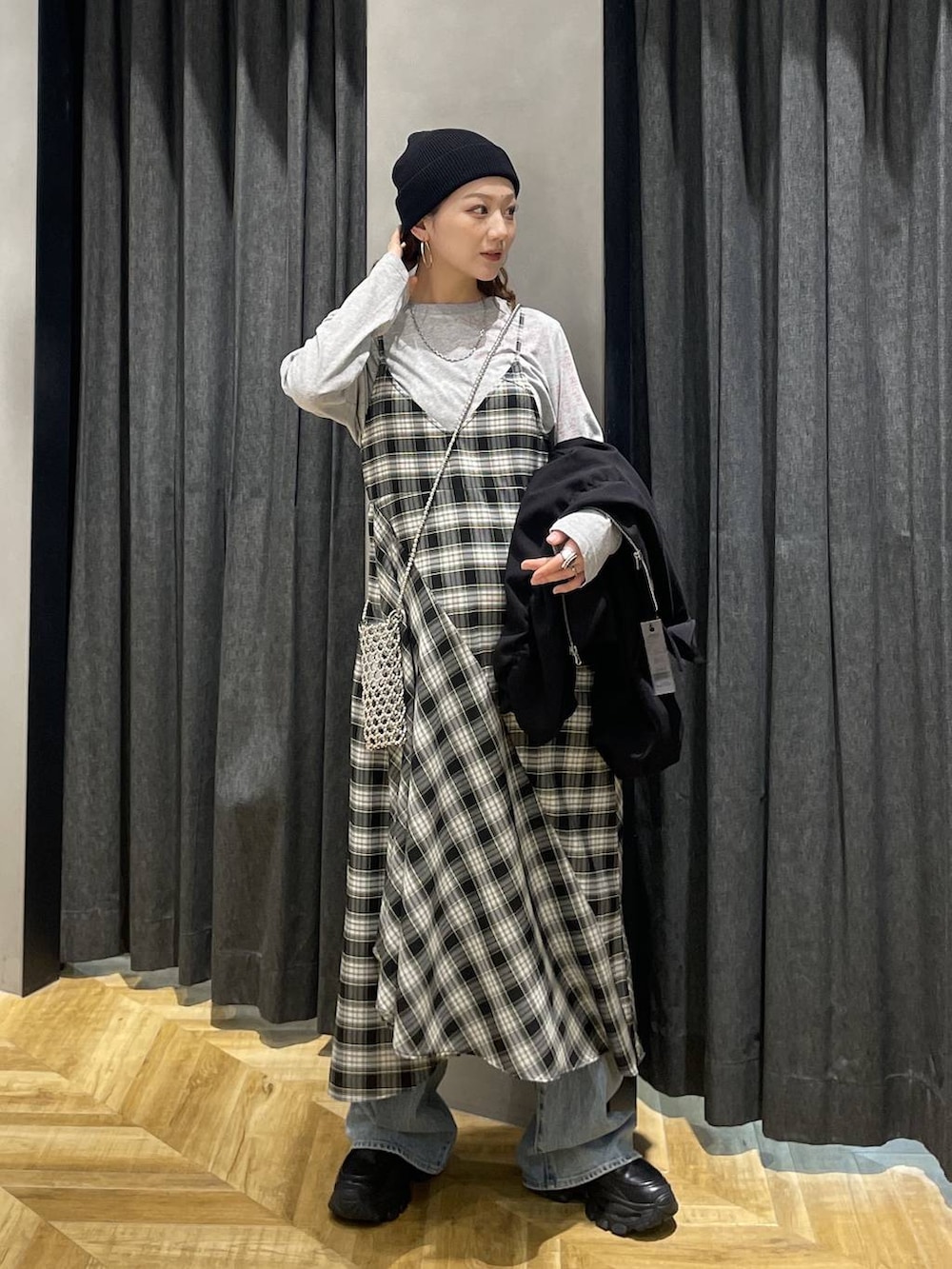 ブラック系のローファー、ブルー系のデニムパンツ、ブラック系のワンピースを着用したレディースの春コーディネートの6枚目の写真