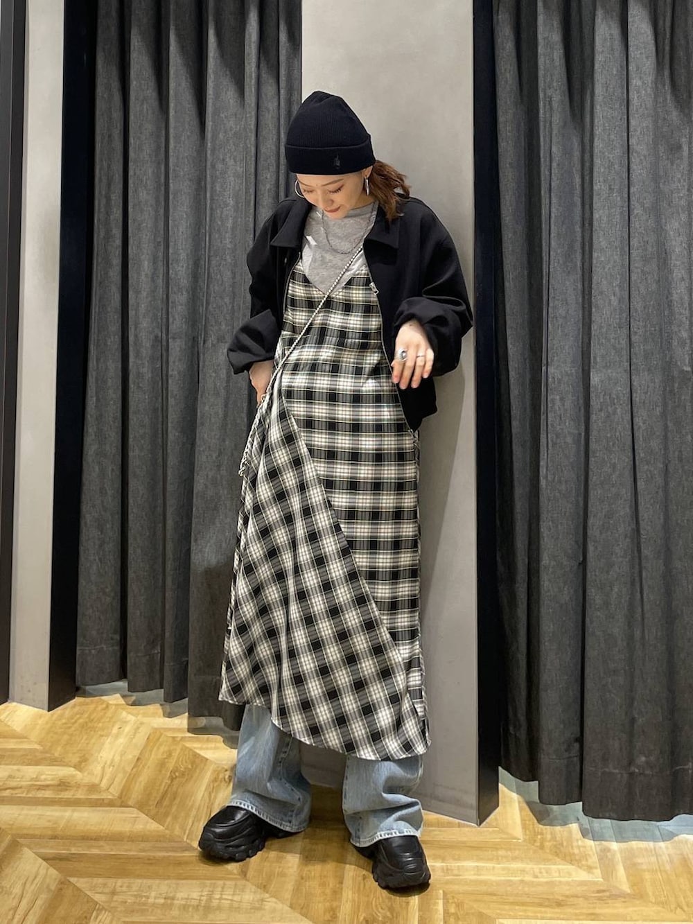 ブラック系のローファー、ブルー系のデニムパンツ、ブラック系のワンピースを着用したレディースの春コーディネートの7枚目の写真