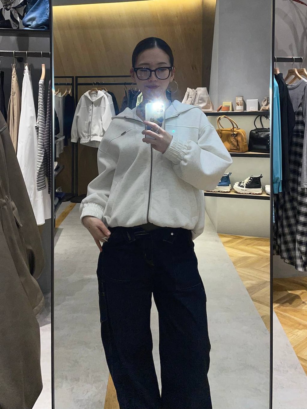 ベージュ系のブルゾン、ベージュ系のモカシン/デッキシューズ、ブルー系のデニムパンツを着用したレディースの春コーディネートの4枚目の写真