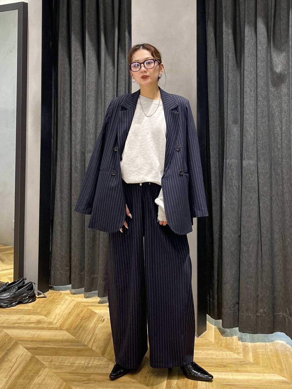 ブラック系のローファー、グレー系のスウェット、ブルー系のスラックスを着用したレディースの冬コーディネートの5枚目の写真