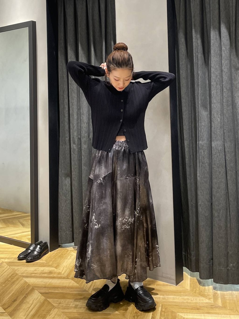 ブラック系のローファー、ブラック系のブルゾン、シルバー系のスカートを着用したレディースの冬コーディネートの3枚目の写真