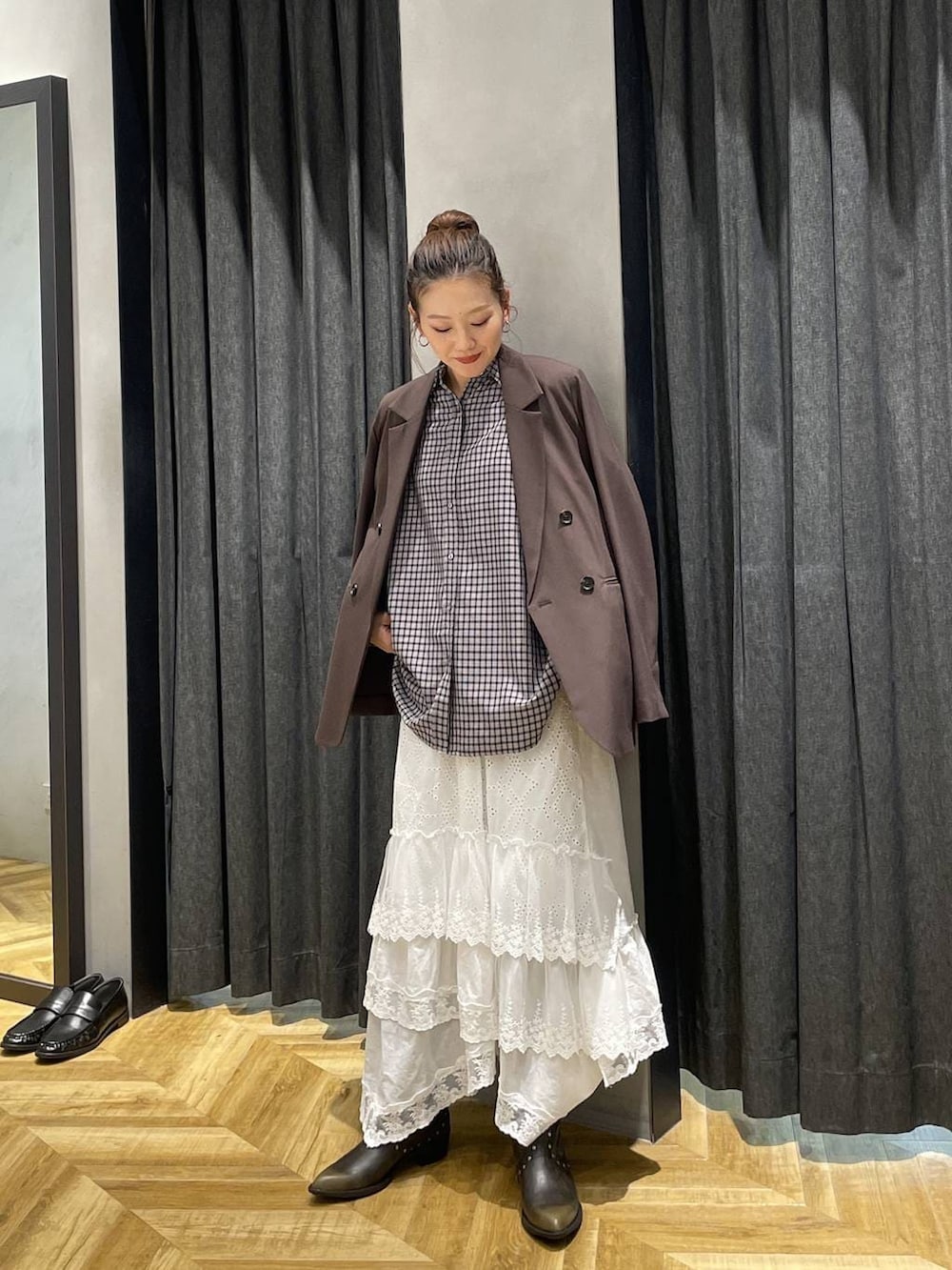 ブラック系のシャツ/ブラウス、ブラウン系のテーラードジャケット、ブラック系のブーツを着用したレディースの冬コーディネートの3枚目の写真